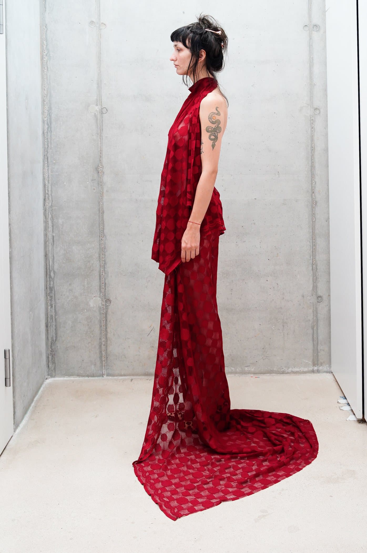 Red sheer check gown, draped at the hip with a pooled train
